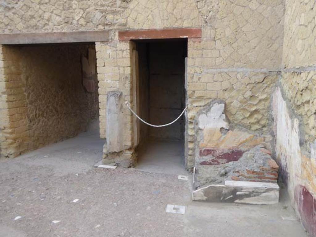 V 7, Herculaneum, October 2014. Looking towards north-west corner of atrium, with entrance corridor, doorway to small room, and remains of lararium.  Photo courtesy of Michael Binns.